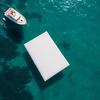Tapete flutuante branco sobre o mar ao lado de uma lancha